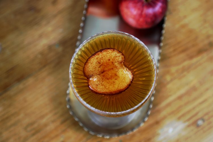 cinnamon apple manhattan with a dried apple slice garnish